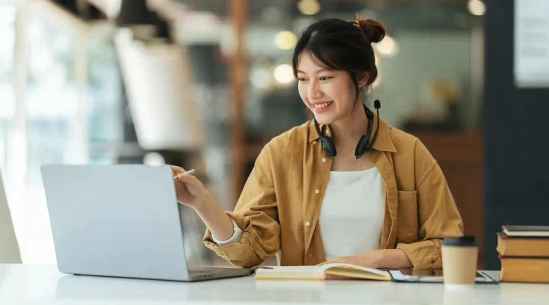 Femme travaillant sur un ordinateur portable dans un bureau moderne, concentrée sur ses tâches.