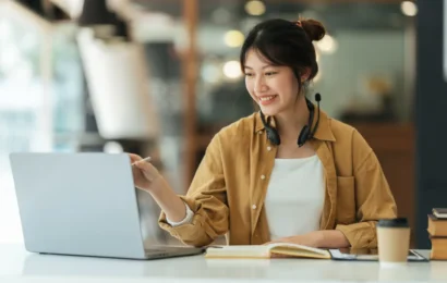 Femme travaillant sur un ordinateur portable dans un bureau moderne, concentrée sur ses tâches.